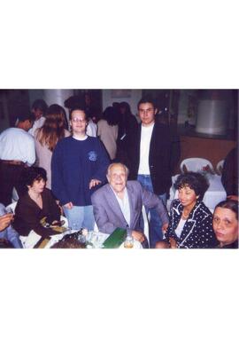 Sergio Magnani com pessoas não identificadas em uma festa.